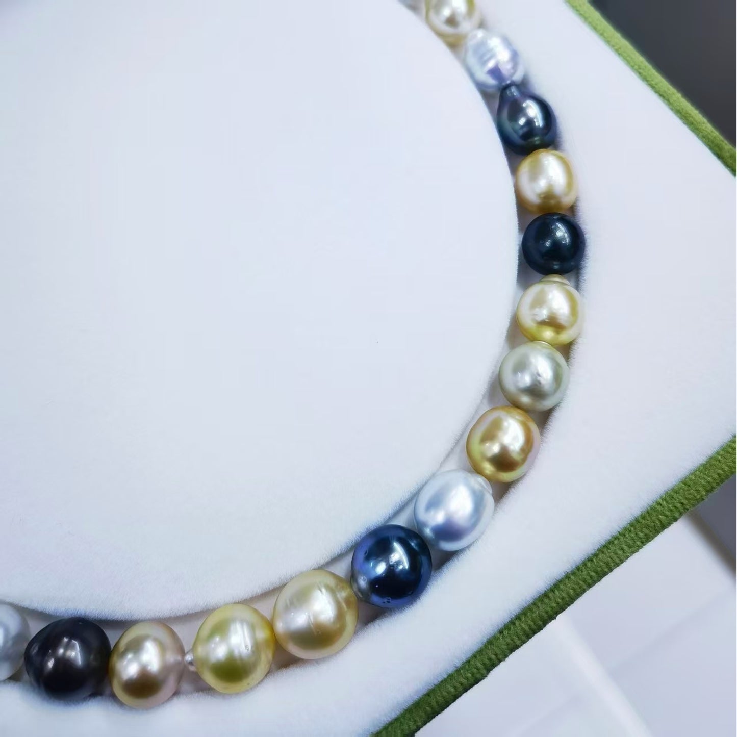 Close-up detail of white, golden, and dark baroque pearls in finished mixed pearl necklace