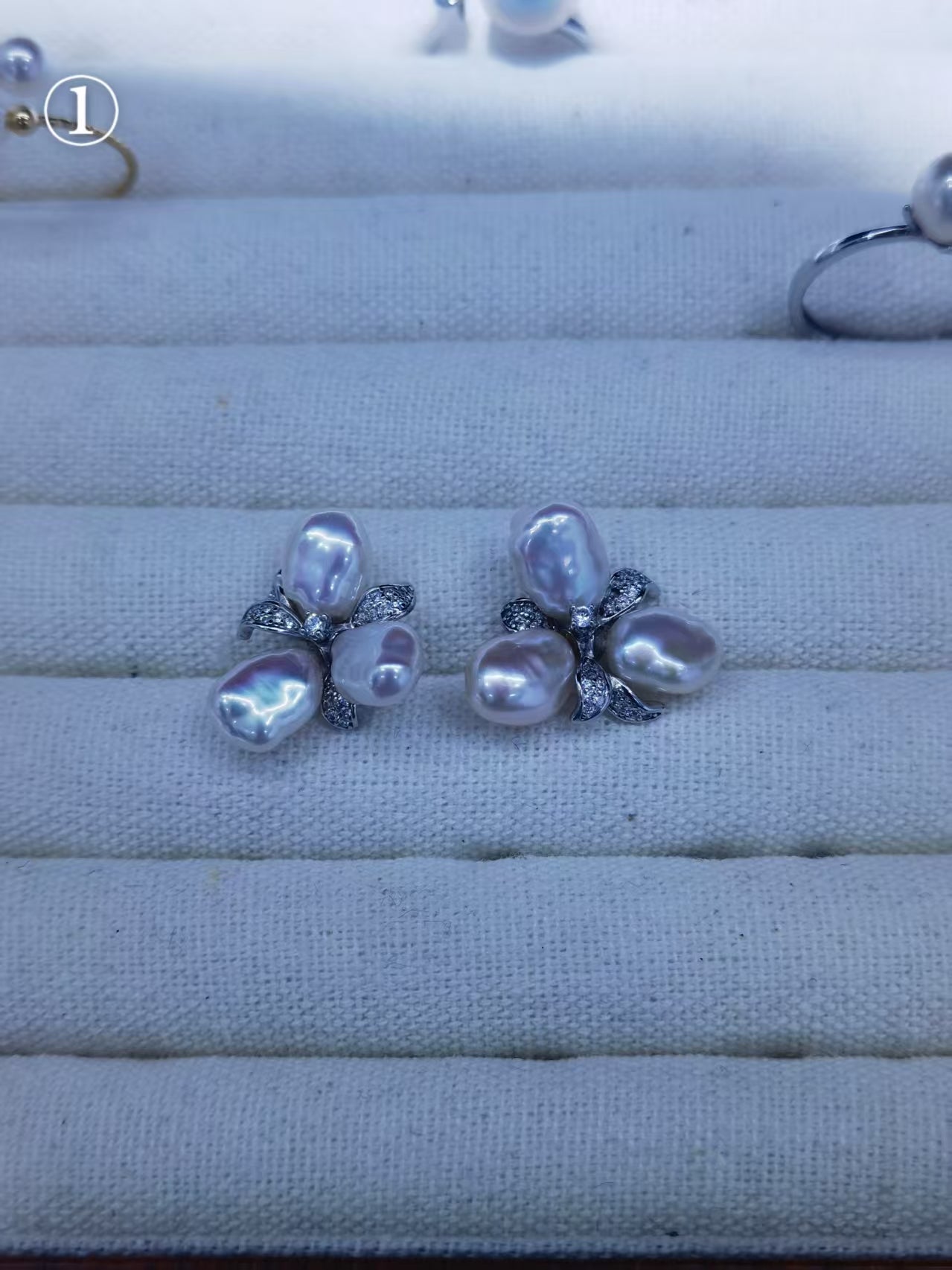 Freshwater baroque pearl floral earrings with soft lavender overtones on jewelry display